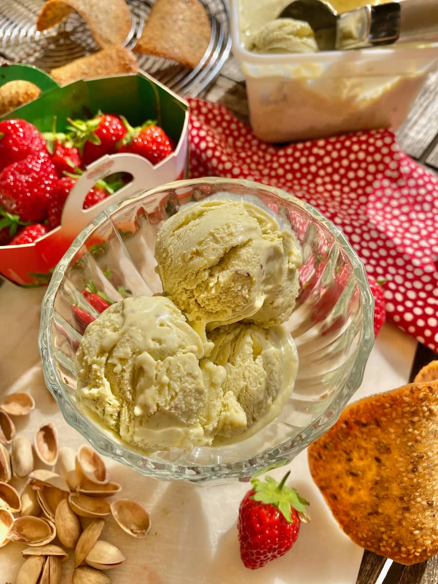 scoops of creamy homemade pistachio ice cream in a glass coupe
